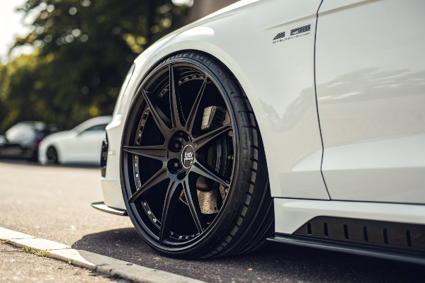 Close-up of black rim on white car